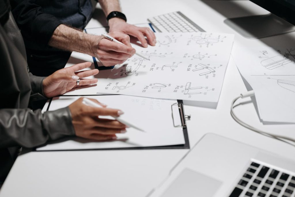Engineers collaborating on product design sketches for manufacturability and prototyping in an OEM workspace