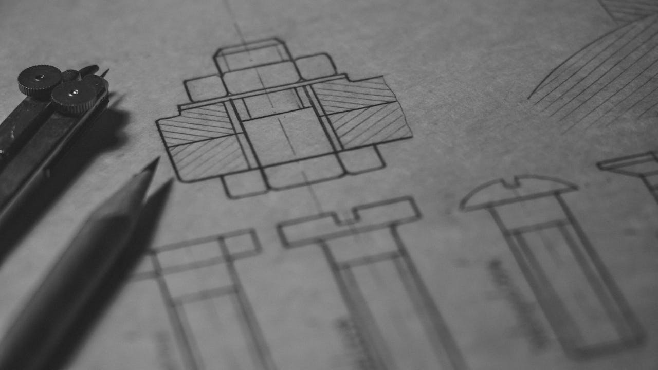 Close-up of mechanical engineering sketches and tools used in industrial product design and development planning