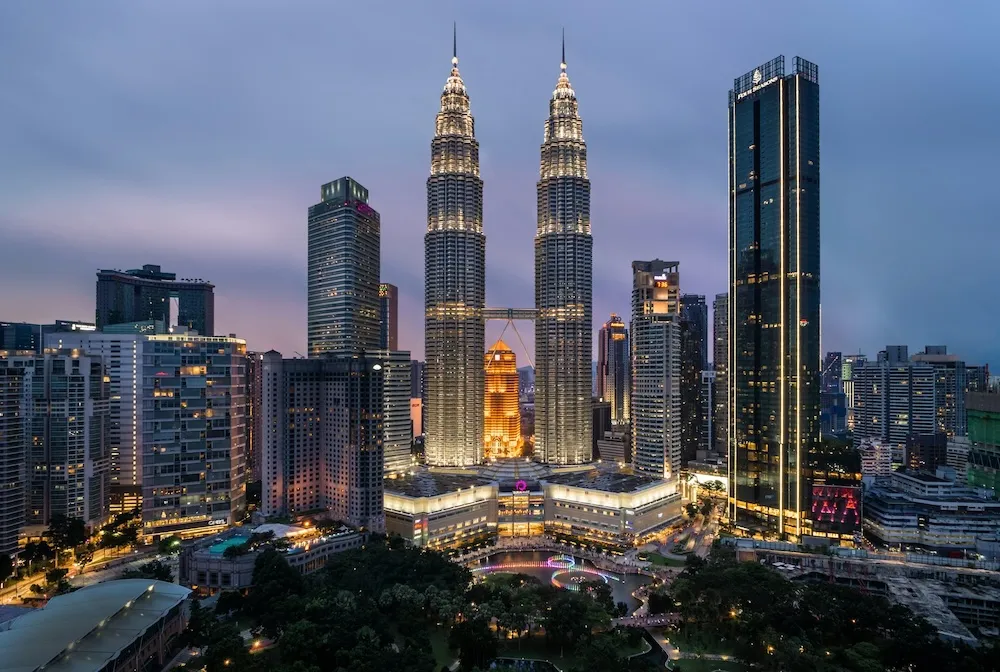 A stunning evening view of the Petronas Twin Towers and the Kuala Lumpur city skyline, showcasing Malaysia's modern architecture and vibrant urban landscape.