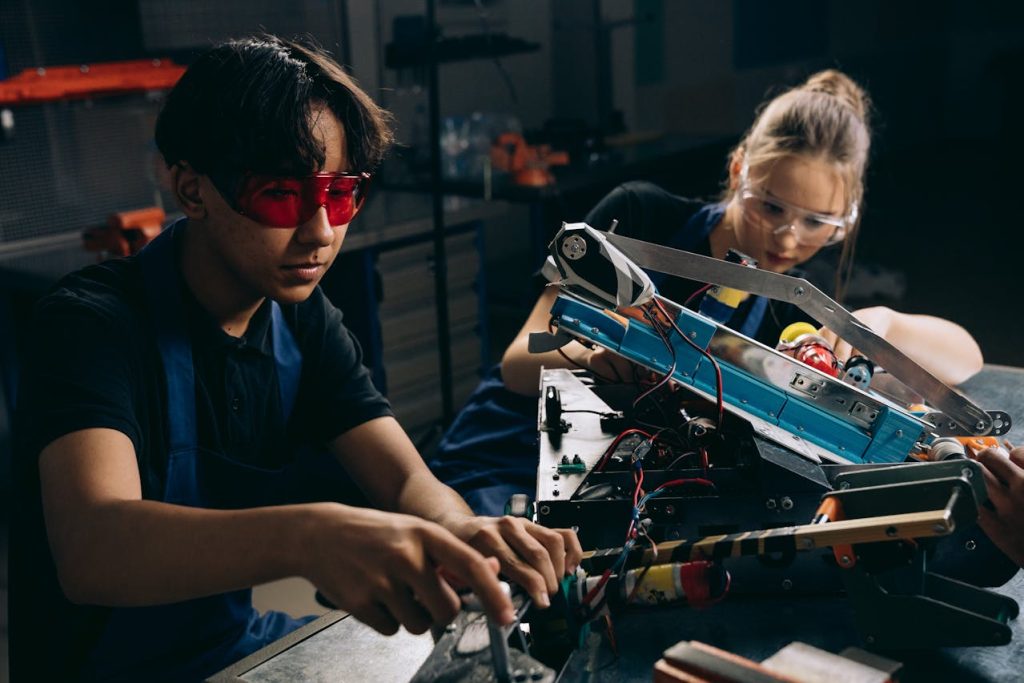 Two young engineers work on assembling a mechanical prototype, highlighting precision in low-volume production.